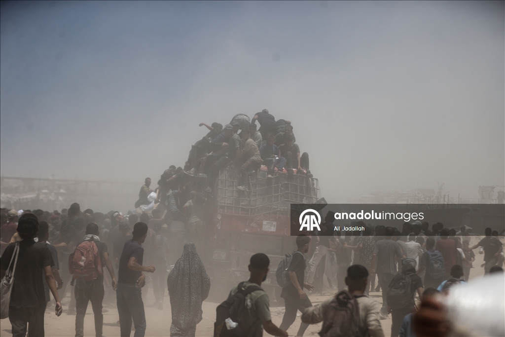Palestinians receive limited amount of flour and infant formula at distribution point in Gaza