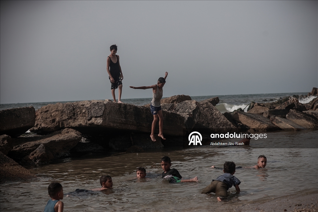 Gaza residents escape tent heat by heading to the coast