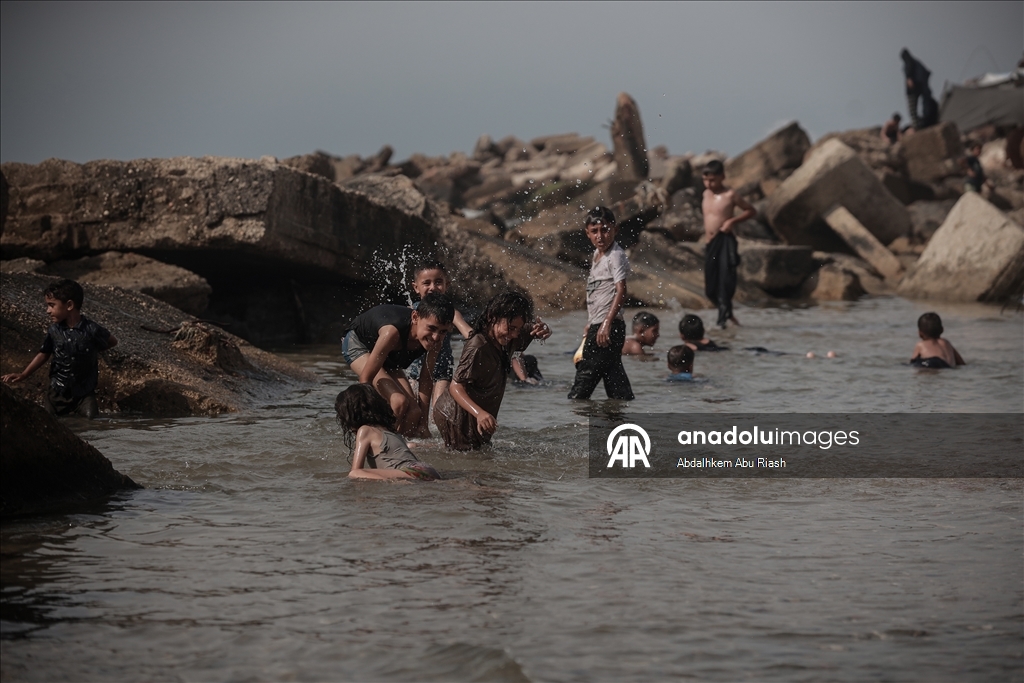 Gaza residents escape tent heat by heading to the coast