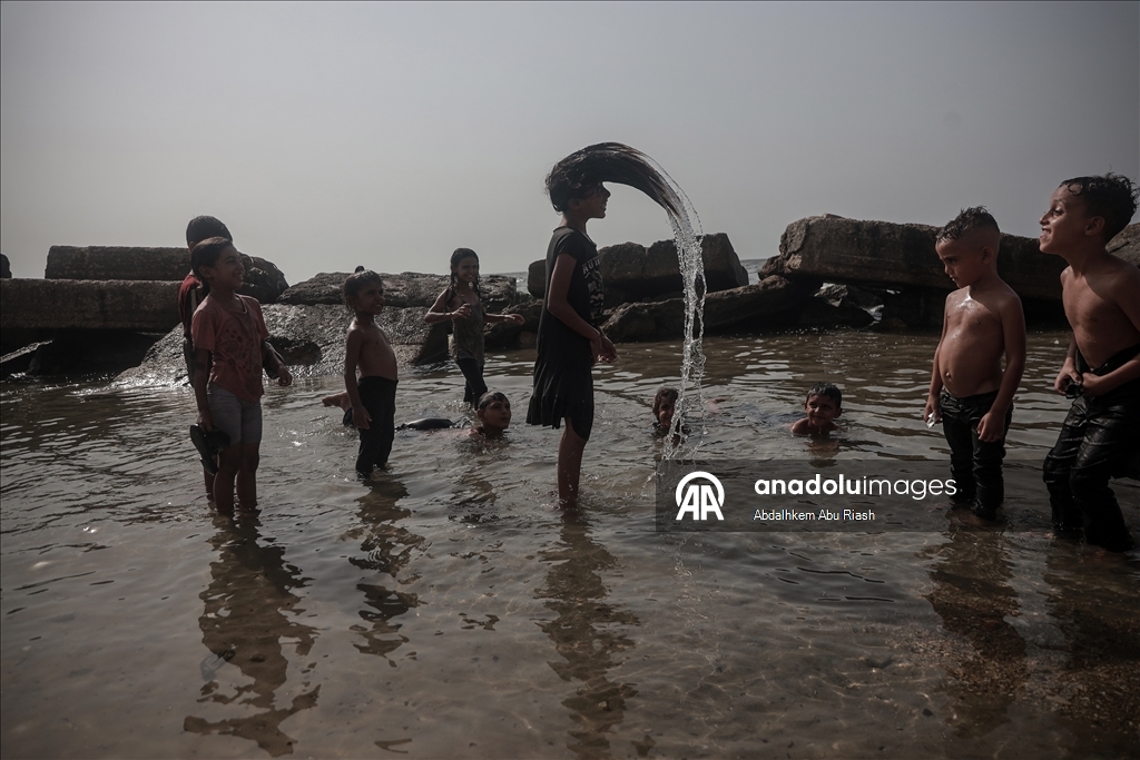 Gaza residents escape tent heat by heading to the coast