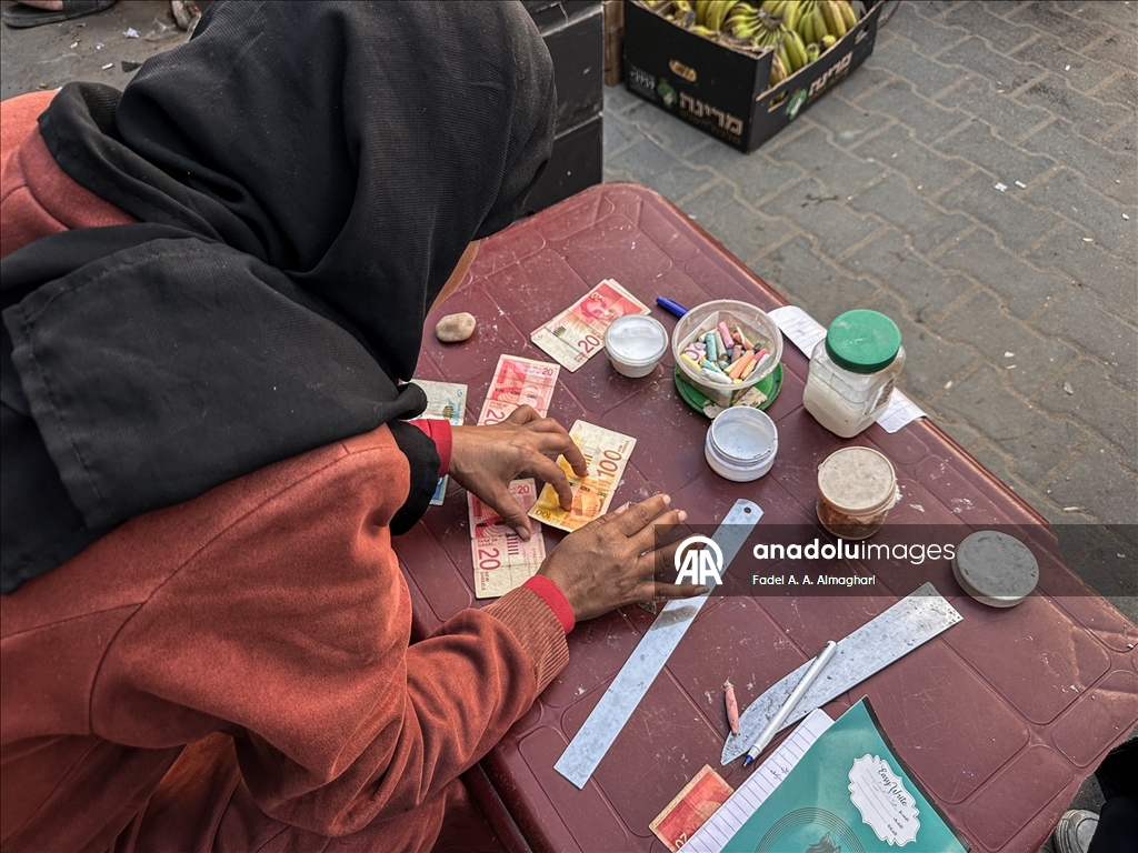 Filistinli kadın, eski ve yırtılmış banknotları onararak ailesinin geçimini sağlıyor