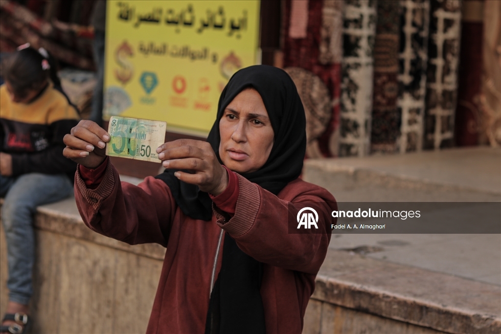 Filistinli kadın, eski ve yırtılmış banknotları onararak ailesinin geçimini sağlıyor