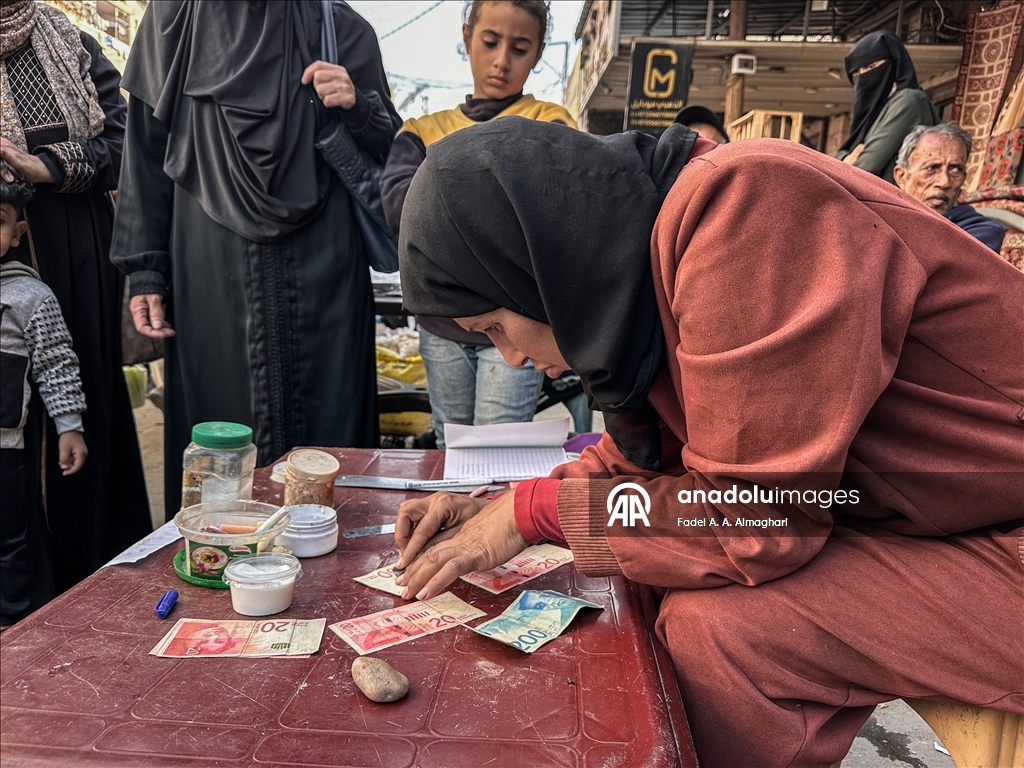 Filistinli kadın, eski ve yırtılmış banknotları onararak ailesinin geçimini sağlıyor