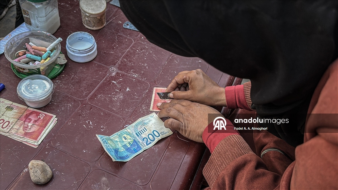 Filistinli kadın, eski ve yırtılmış banknotları onararak ailesinin geçimini sağlıyor