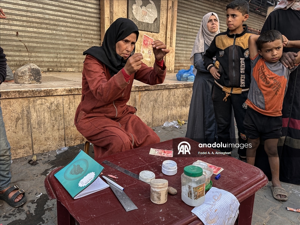 Filistinli kadın, eski ve yırtılmış banknotları onararak ailesinin geçimini sağlıyor