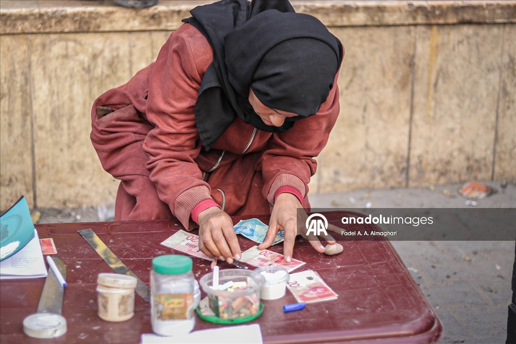 Filistinli kadın, eski ve yırtılmış banknotları onararak ailesinin geçimini sağlıyor
