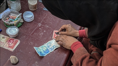 Filistinli kadın, eski ve yırtılmış banknotları onararak ailesinin geçimini sağlıyor