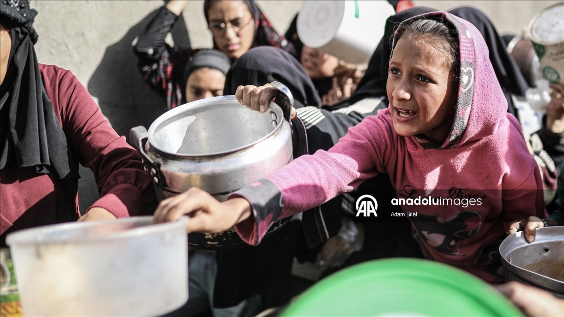 Displaced Palestinians receive hot meal in Deir al-Balah