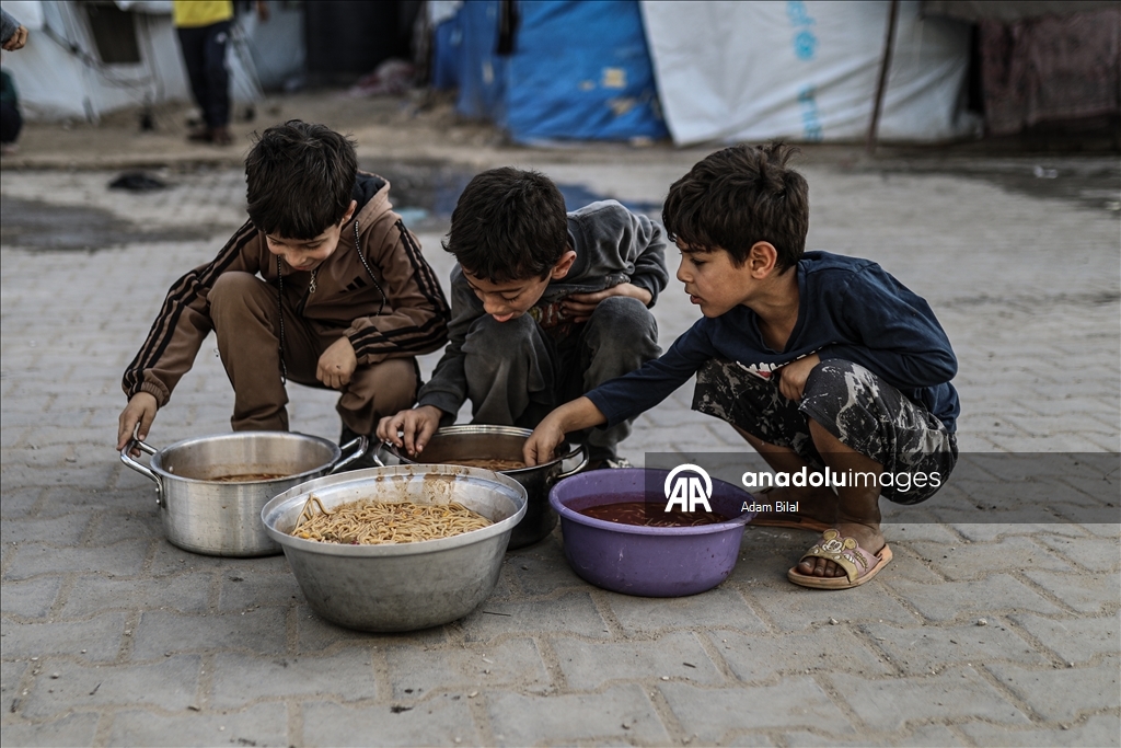 Displaced Palestinians receive hot meal in Deir al-Balah