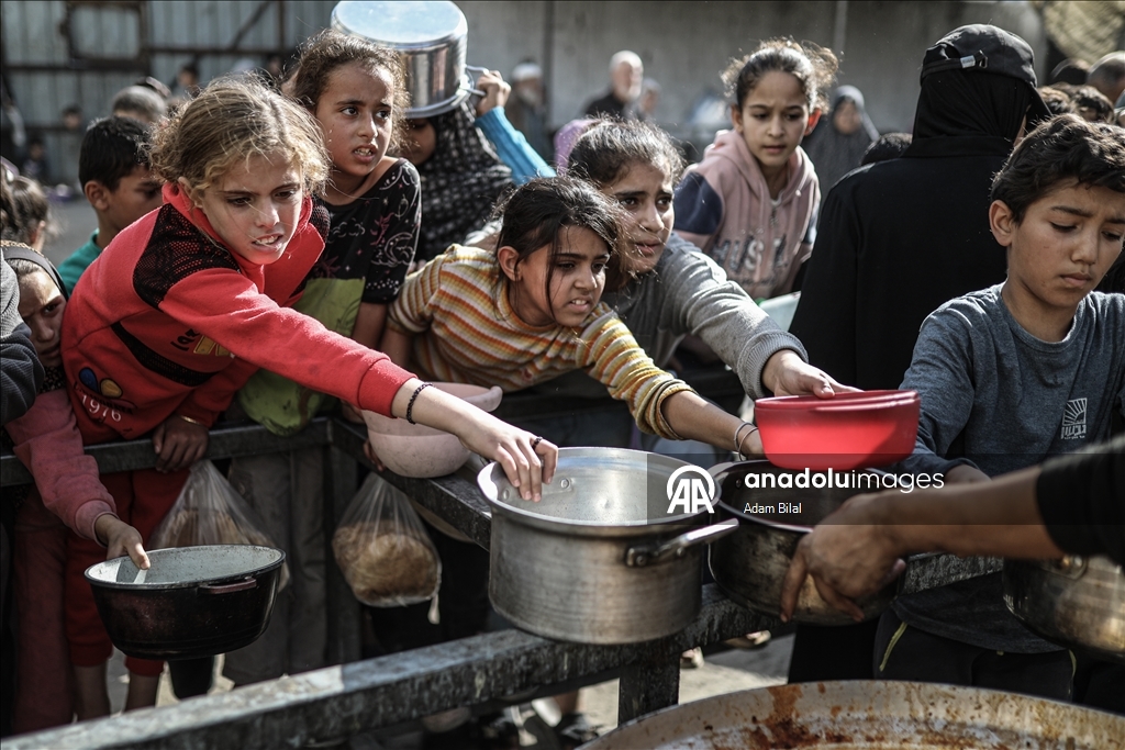 Displaced Palestinians receive hot meal in Deir al-Balah