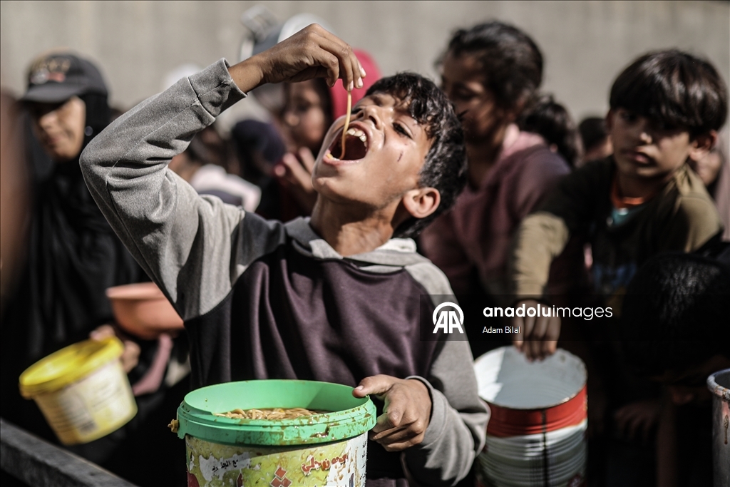 Displaced Palestinians receive hot meal in Deir al-Balah