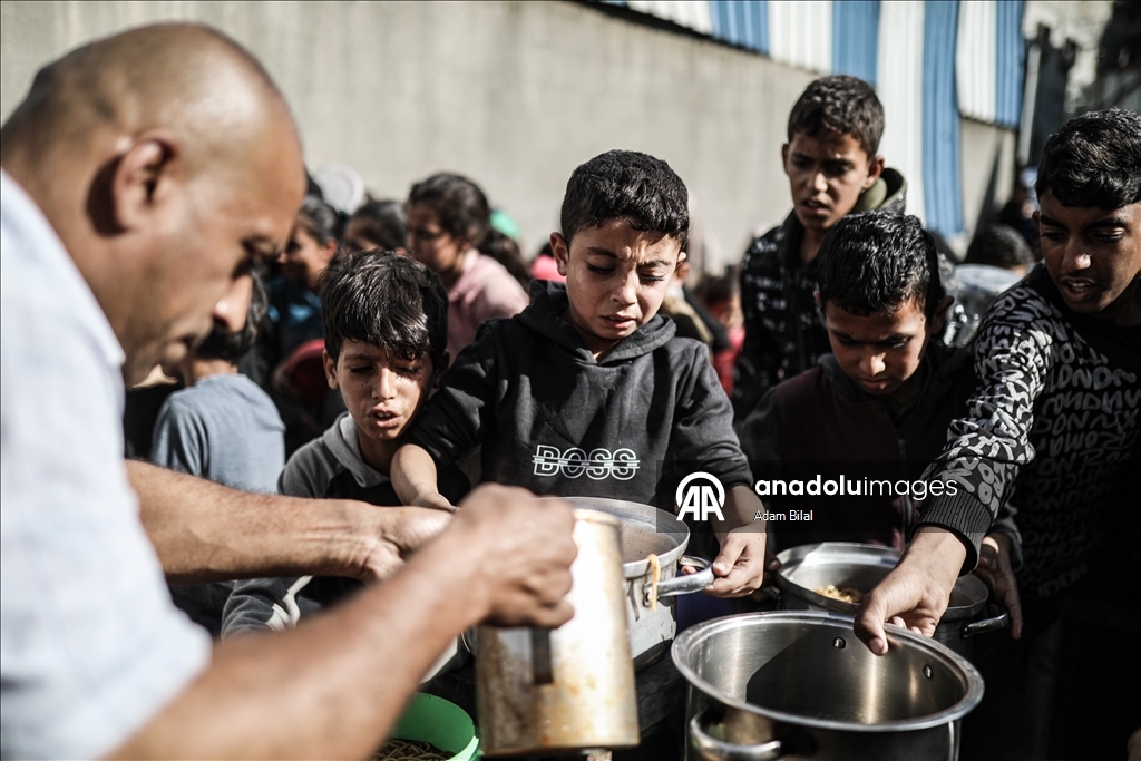 Displaced Palestinians receive hot meal in Deir al-Balah