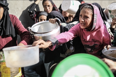 Displaced Palestinians receive hot meal in Deir al-Balah