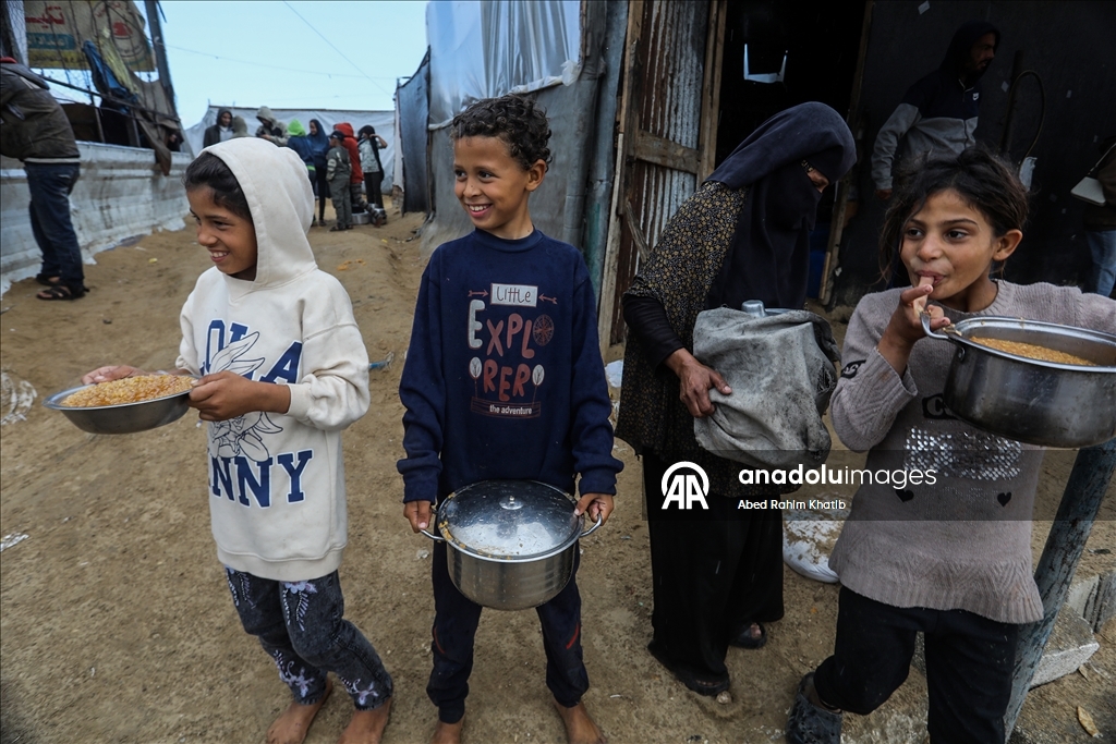Palestinians receive hot meals by charity organizations in Gaza