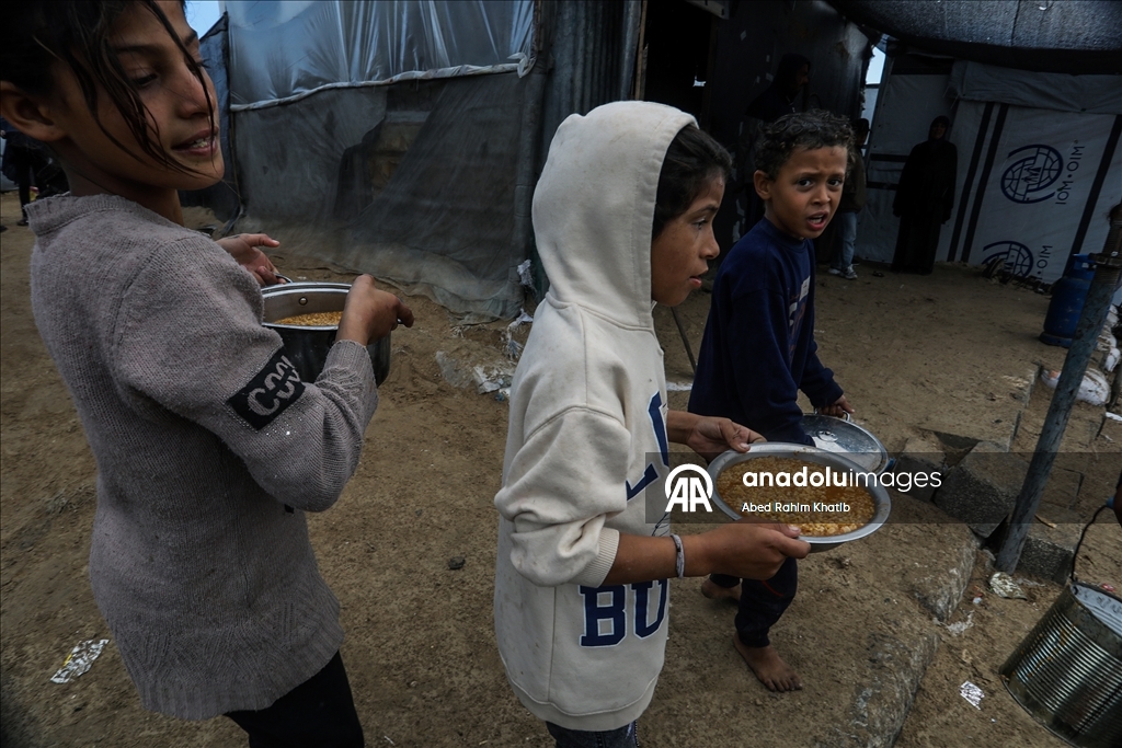 Palestinians receive hot meals by charity organizations in Gaza