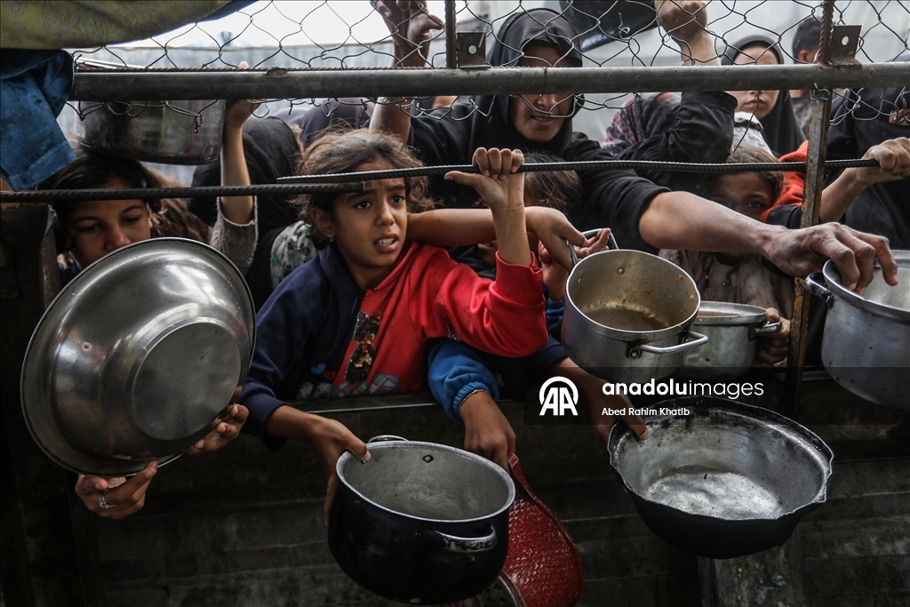 Palestinians receive hot meals by charity organizations in Gaza