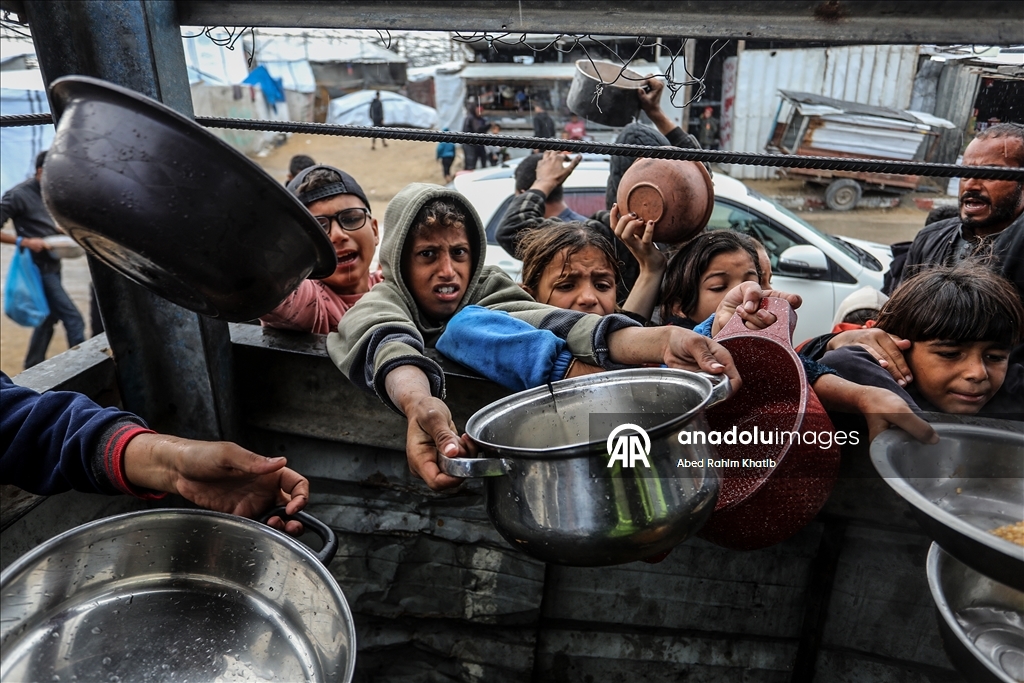 Palestinians receive hot meals by charity organizations in Gaza