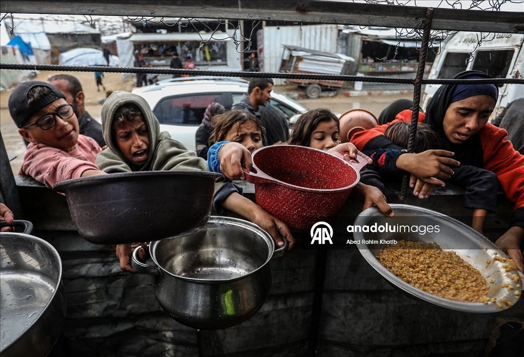 Palestinians receive hot meals by charity organizations in Gaza