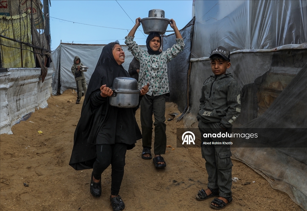 Palestinians receive hot meals by charity organizations in Gaza