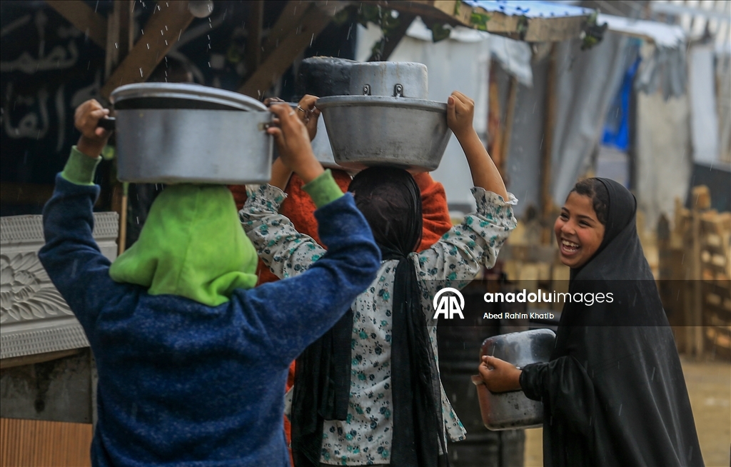 Palestinians receive hot meals by charity organizations in Gaza