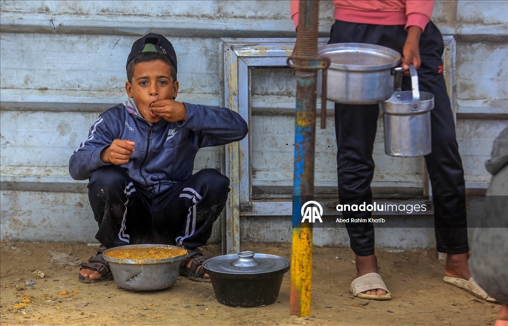 Palestinians receive hot meals by charity organizations in Gaza