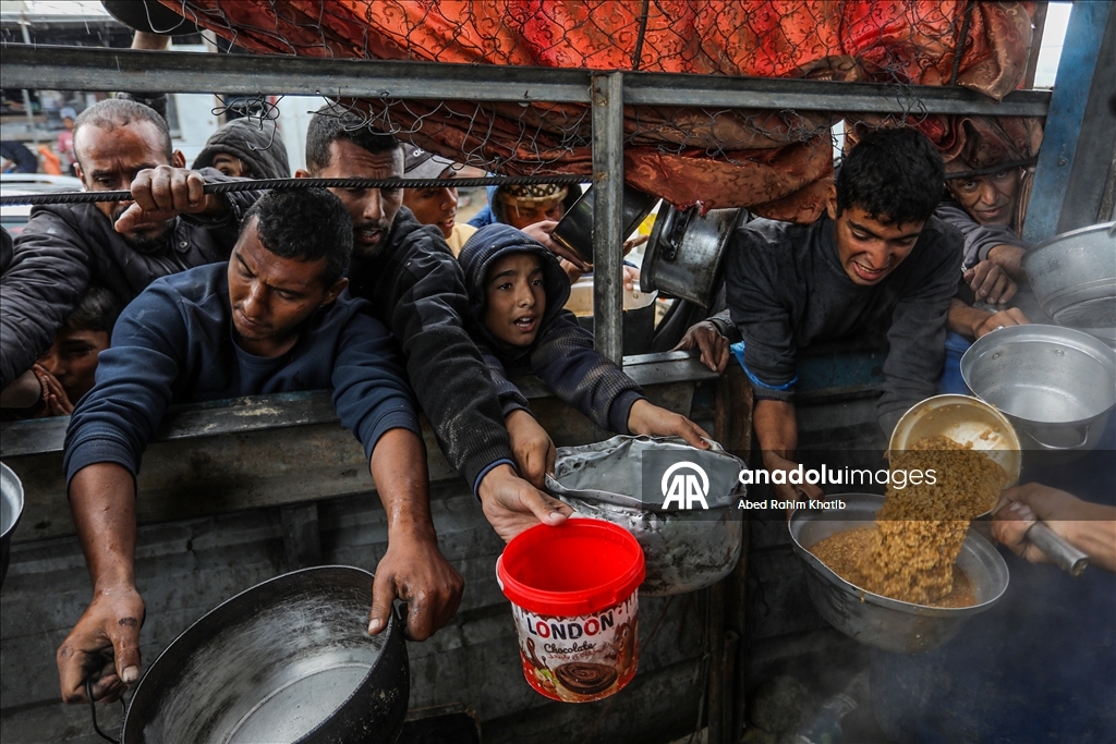 Palestinians receive hot meals by charity organizations in Gaza