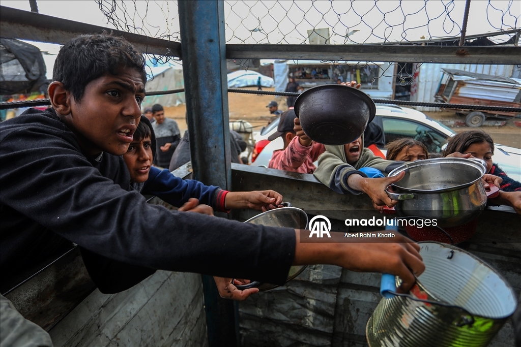 Palestinians receive hot meals by charity organizations in Gaza
