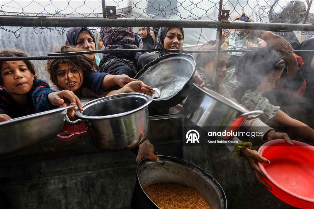 Palestinians receive hot meals by charity organizations in Gaza