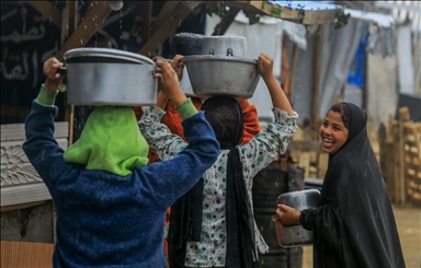 Palestinians receive hot meals by charity organizations in Gaza