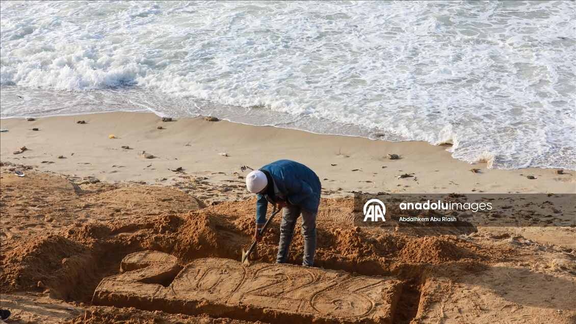Filistinli resim sanatçısı Ebu Cerad, Gazze sahilinde “2026” yazdı