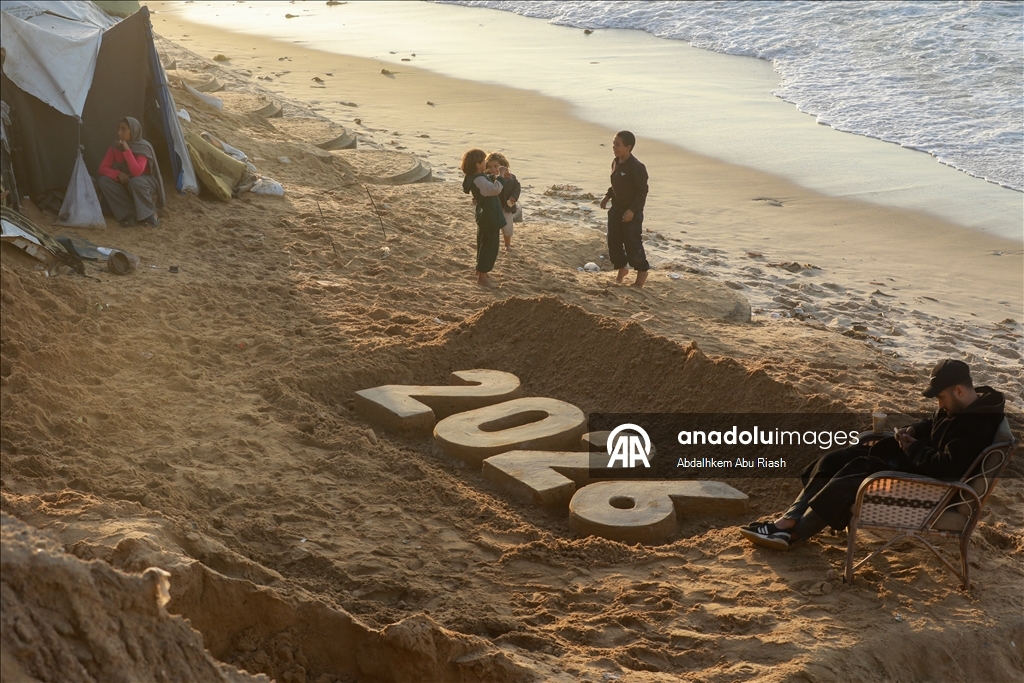 Filistinli resim sanatçısı Ebu Cerad, Gazze sahilinde “2026” yazdı