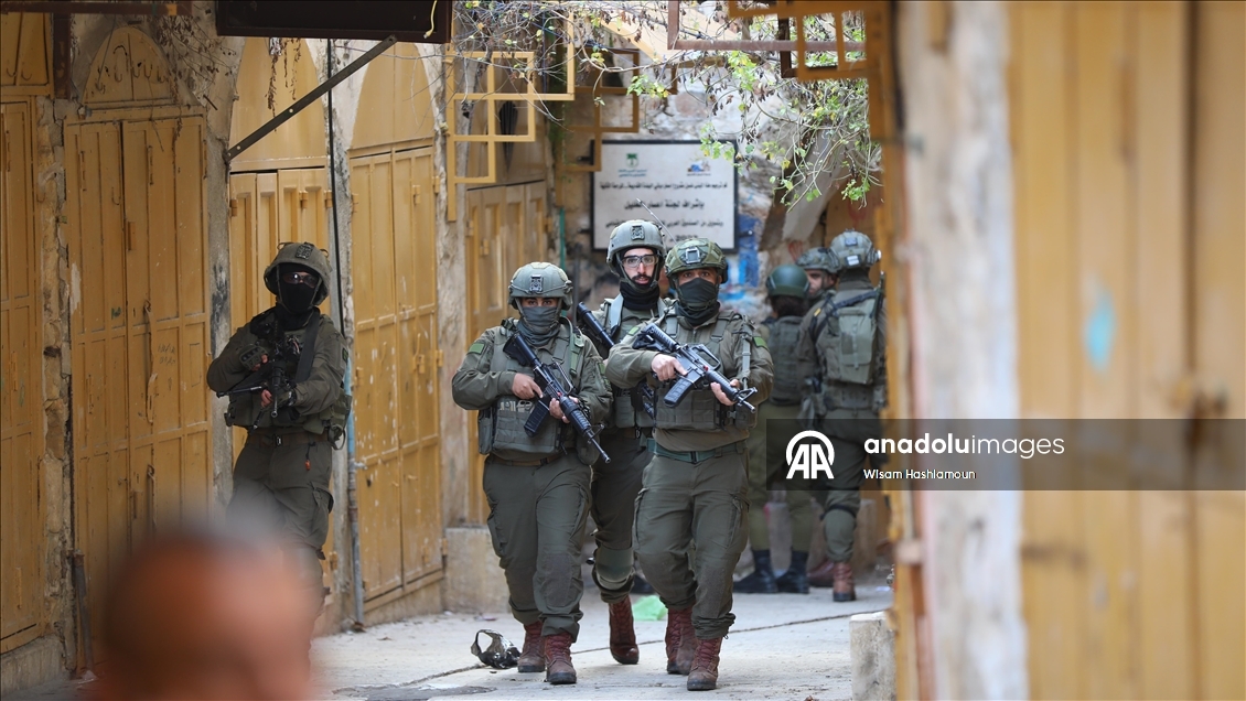 İsrail askerleri ile Filistin topraklarını gasbeden yerleşimciler, El Halil kentine baskın düzenledi