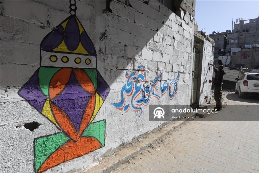 Filistinli Hani, İsrail saldırılarında yıkılan evlerin duvarlarına Ramazan ayı için resimler çiziyor
