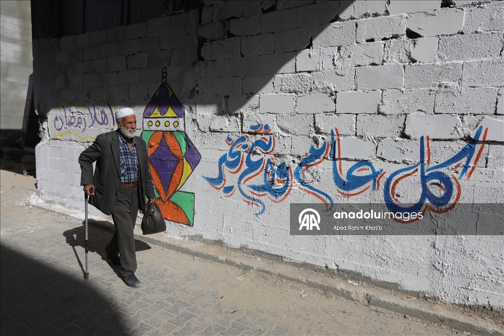 Filistinli Hani, İsrail saldırılarında yıkılan evlerin duvarlarına Ramazan ayı için resimler çiziyor