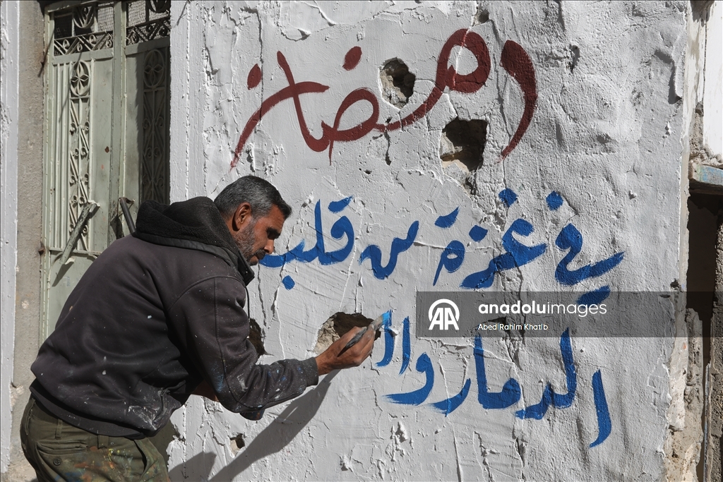 Filistinli Hani, İsrail saldırılarında yıkılan evlerin duvarlarına Ramazan ayı için resimler çiziyor