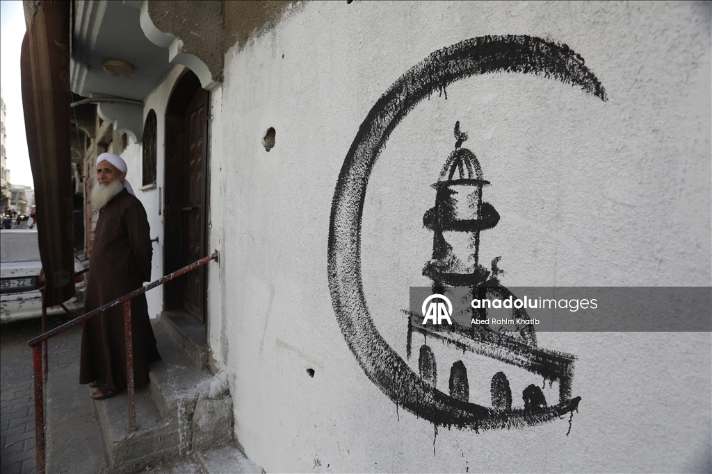 Filistinli Hani, İsrail saldırılarında yıkılan evlerin duvarlarına Ramazan ayı için resimler çiziyor