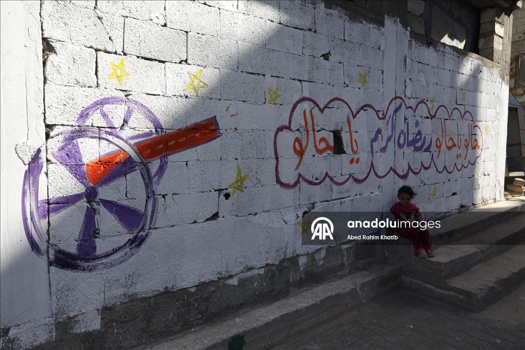 Filistinli Hani, İsrail saldırılarında yıkılan evlerin duvarlarına Ramazan ayı için resimler çiziyor