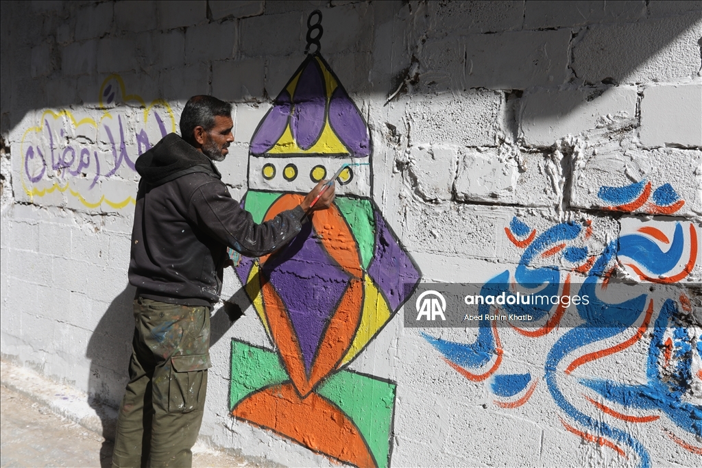 Filistinli Hani, İsrail saldırılarında yıkılan evlerin duvarlarına Ramazan ayı için resimler çiziyor