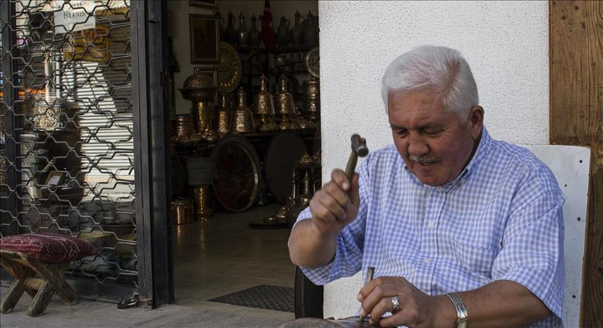 Çıraklıktan ustalığa ömrünü bakır işleme sanatına adayan 65 yaşındaki İhsan Geredeli, 48 yıldır çekiç darbeleriyle bakırı süsleyip müşterilerinin beğenisine sunuyor. ( Muhammed Ali Toruntay - Anadolu Ajansı )